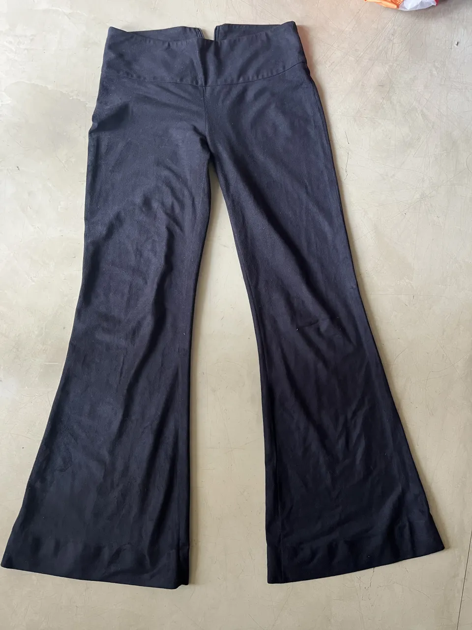 Pantalón negro de tela elastizada con cierre en la parte trasera.