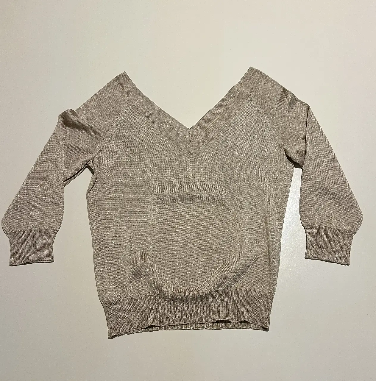 Sweater de mujer color dorado con cuello en V y mangas 3/4. Ideal para un look elegante y sofisticado.