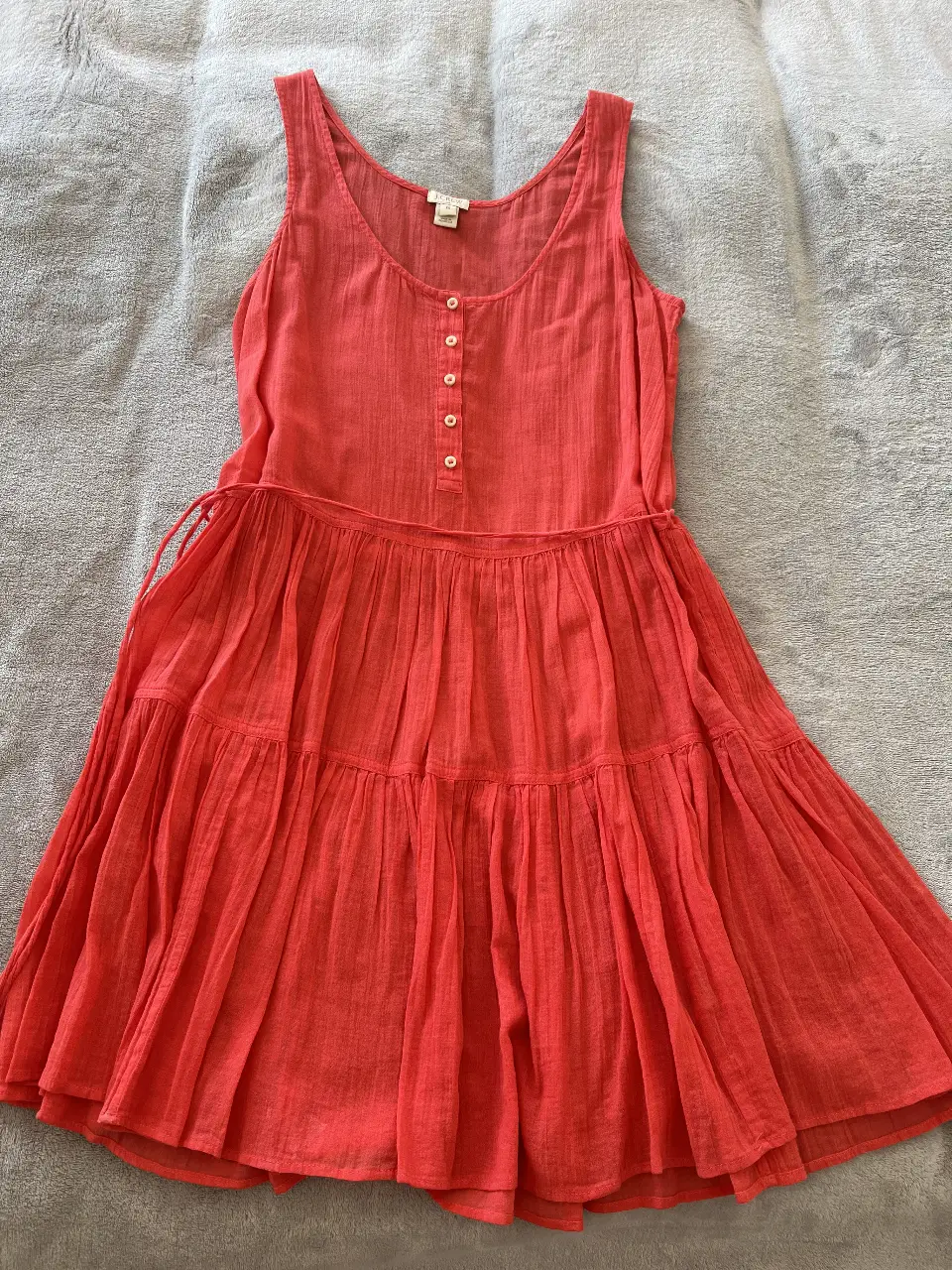 Vestido midi de verano, color coral, con detalles de botones y cintura ajustable. Ideal para un look fresco y casual.