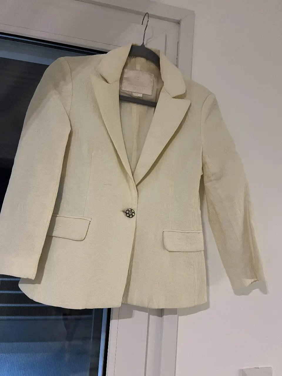 Blazer Akibara Collection color amarillo pastel, con un botón joya. Ideal para un look elegante y sofisticado.
