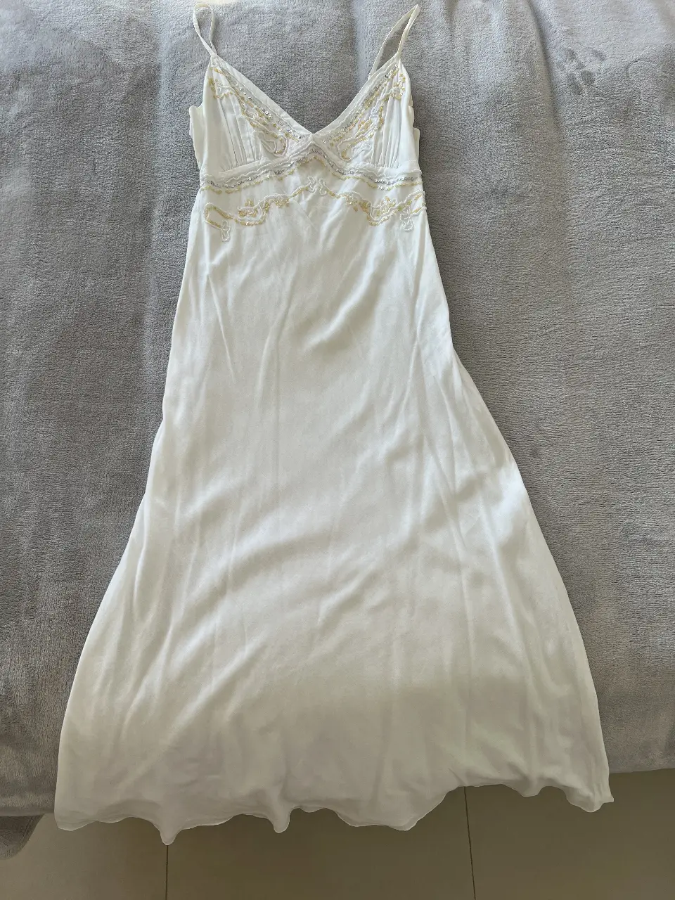 Vestido midi blanco con detalles bordados en la parte superior. Ideal para un look fresco y elegante.