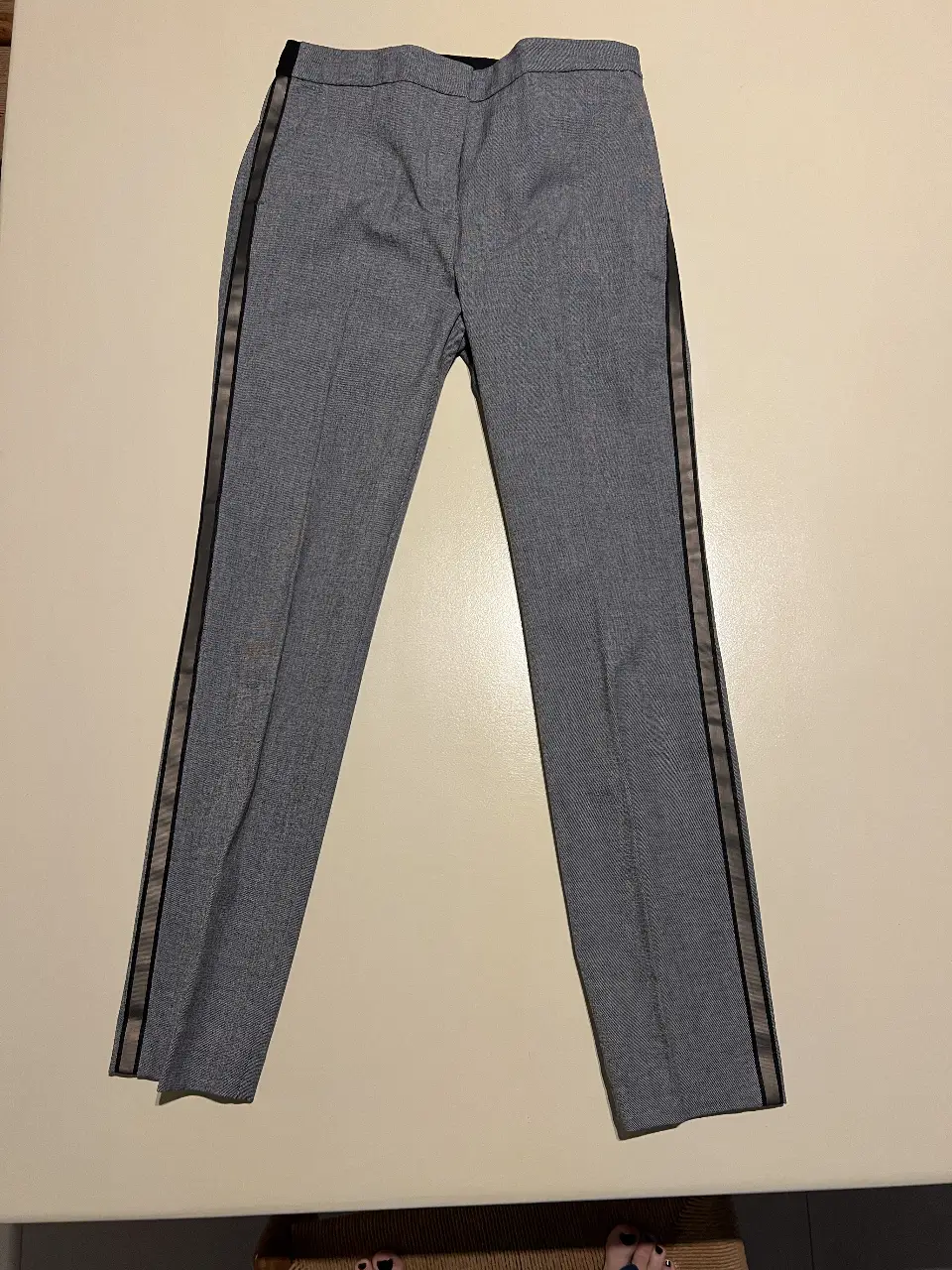 Pantalón sastrero gris con detalle de cinta de gross en los laterales. Talle S, de la marca Zara. Ideal para un look elegante y moderno.