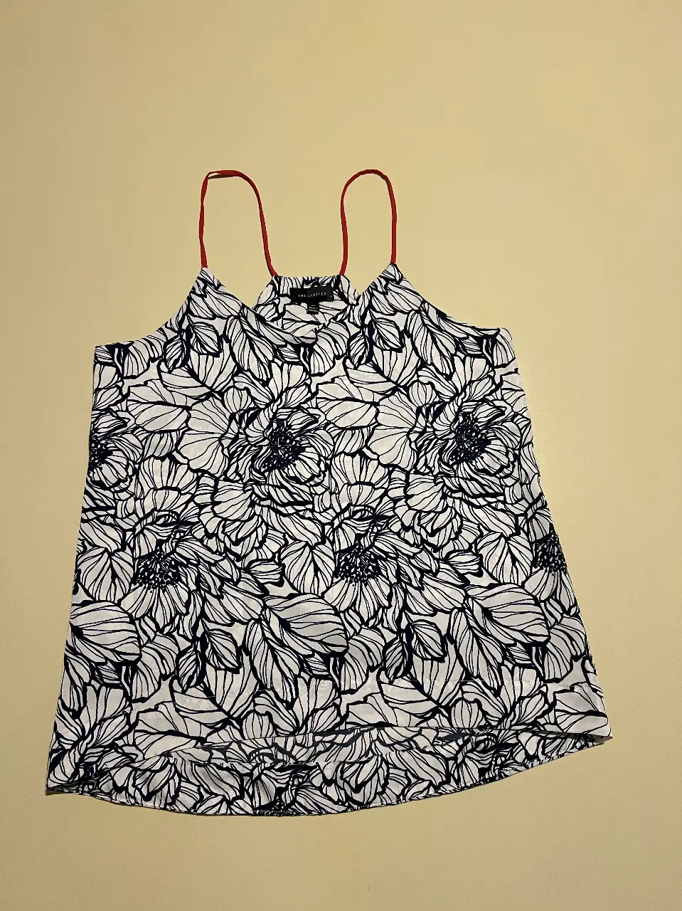 Top de mujer con estampado floral en blanco y azul marino. Tiene tirantes finos rojos y es de la marca The Limited. Ideal para el verano.