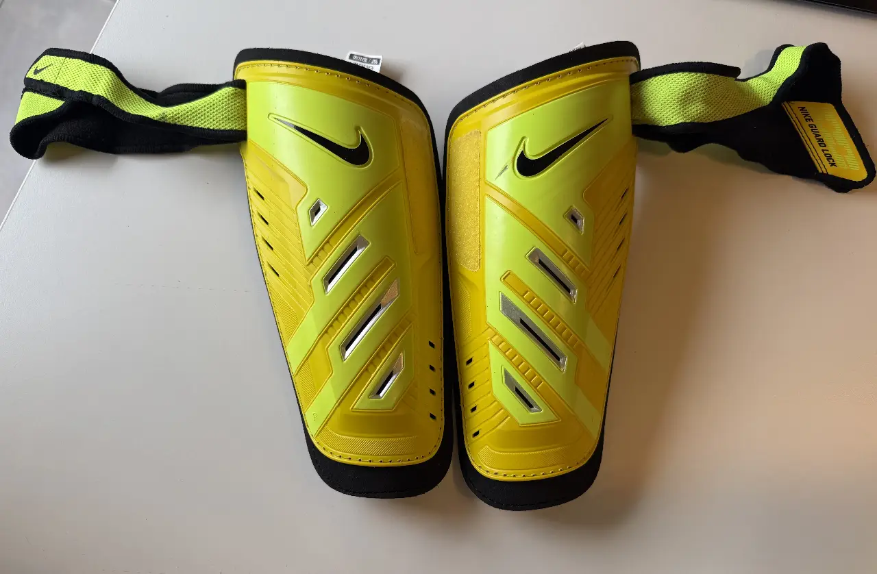 Canilleras de fútbol Nike con tobillera integrada. Color amarillo flúo con negro. Talle M. Diseño ergonómico, livianas y resistentes.Incluyen correas elásticas tipo Guard Lock para mayor ajuste y comodidad. Muy poco uso. Sin detalles ni desgaste.Ideales para entrenamientos y partidos.