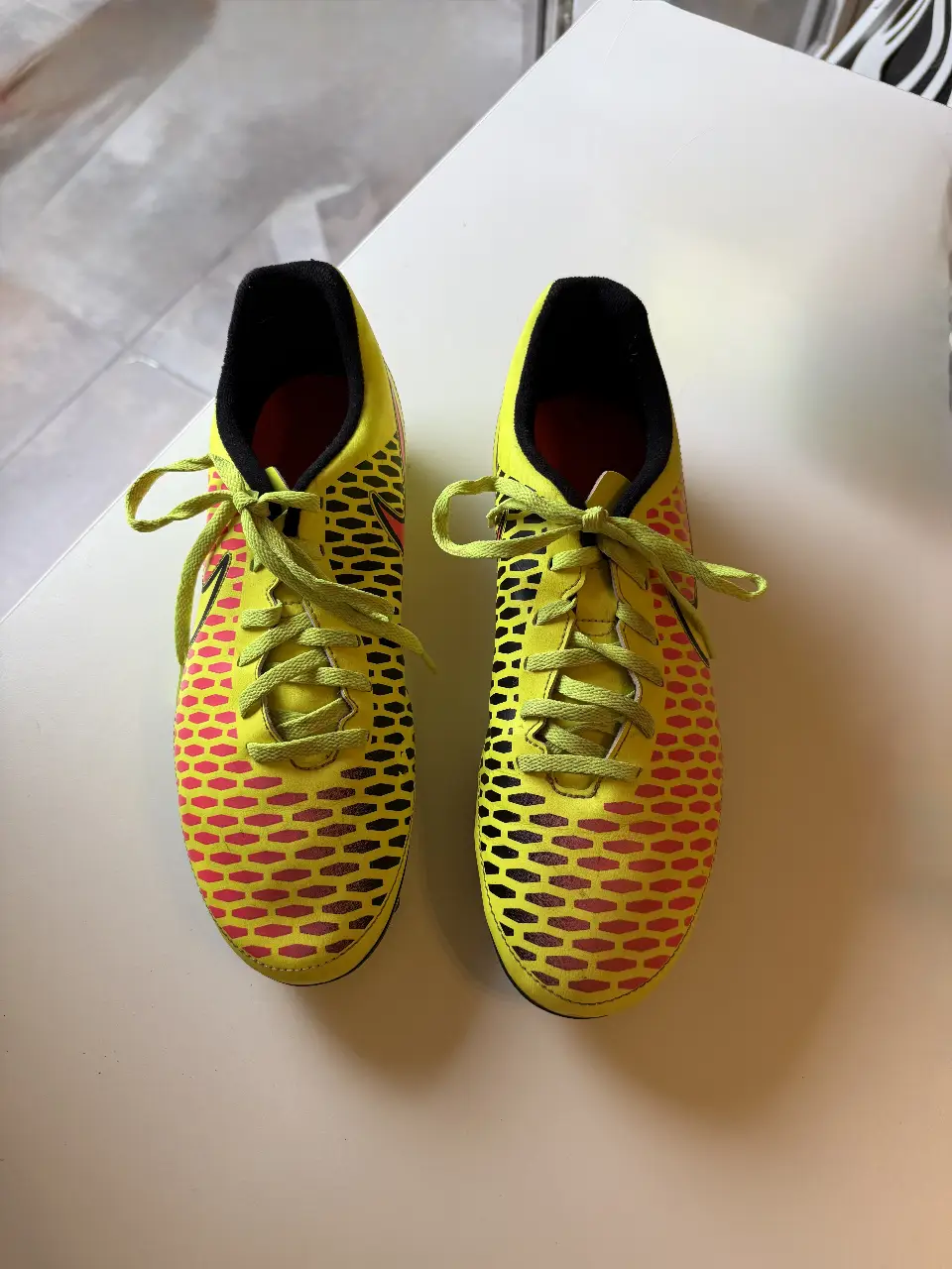 Botines de fútbol Nike Hypervenom Phelon FG, amarillos con detalles en rojo y negro. Tienen tapones para mejor agarre en el campo de juego. Ideales para jugadores que buscan rendimiento y estilo. Talle US 10 (EUR 44). Muy poco uso, están en excelente estado.