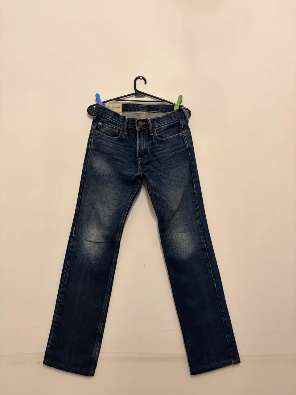 JeansAbercrombie Kids talle 14, de corte recto, tiro medio, color azul oscuro con detalles de desgaste sutiles. Un clásico versátil para tu día a día.