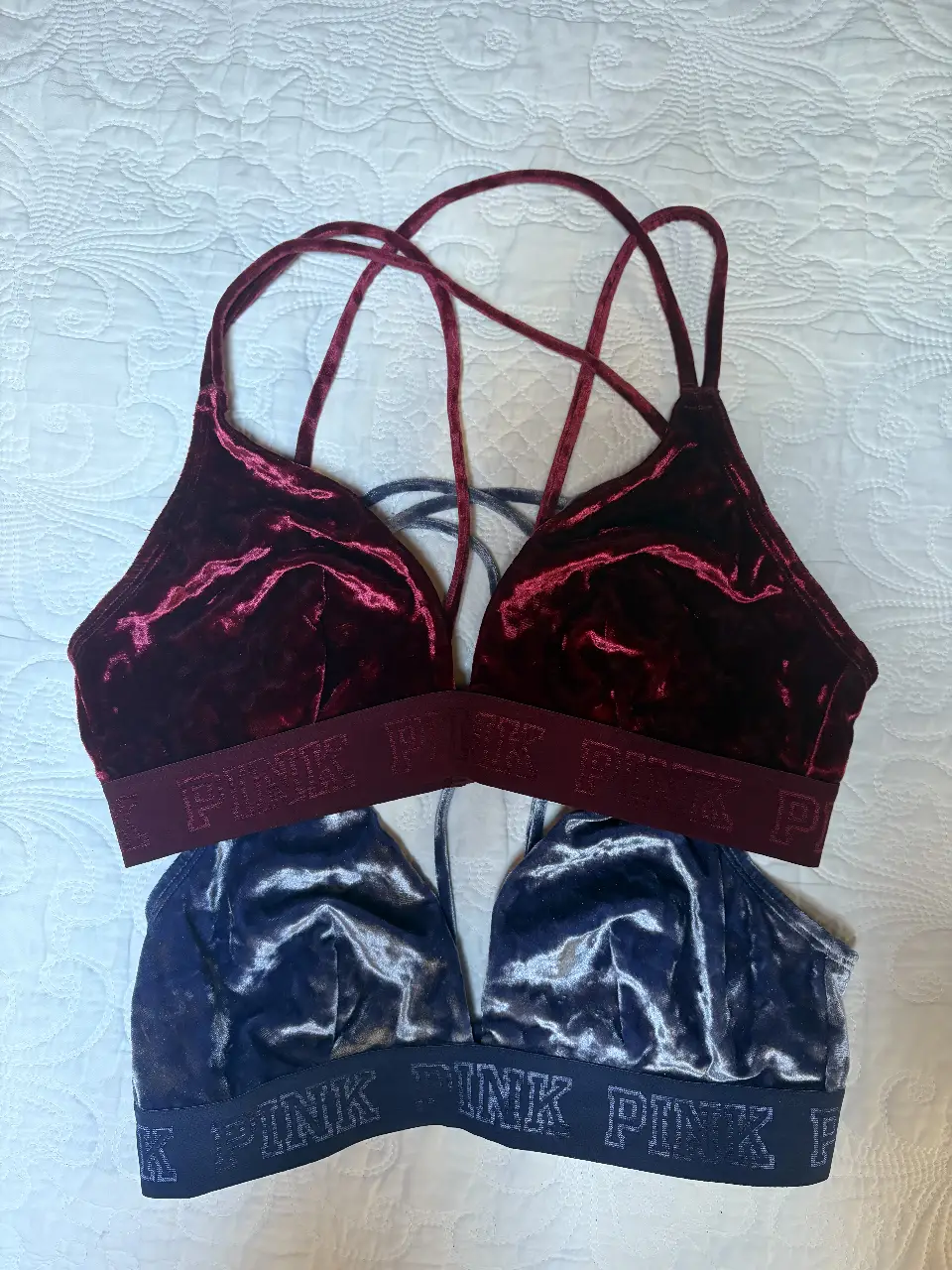 Conjunto de dos corpiños de terciopelo, uno en color bordo  y otro en azul marino. Ambos con el logo "PINK" en la banda inferior.