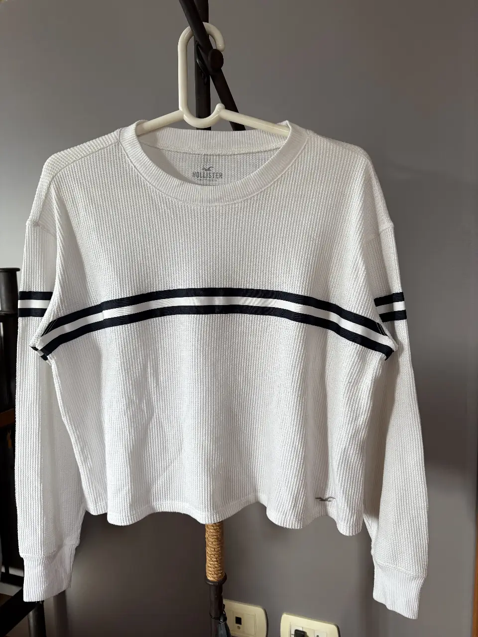 Sweater blanco de waffle con detalles en negro. Cuello redondo y mangas largas. Ideal para un look casual y cómodo.