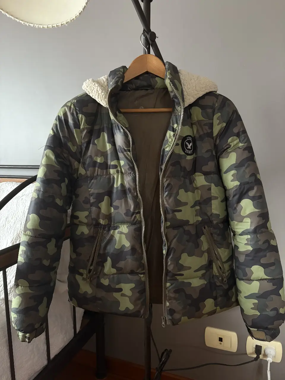 Campera puffer con estampado camuflado, capucha con corderito y cierre. Ideal para el invierno.