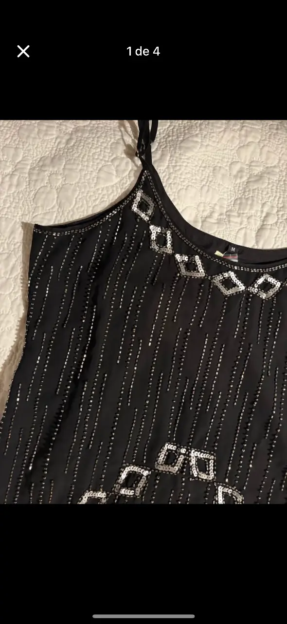 Vestido negro con detalles bordados plateados. Ideal para fiestas y eventos especiales. Diseño con tirantes finos regulables y detalles brillantes.