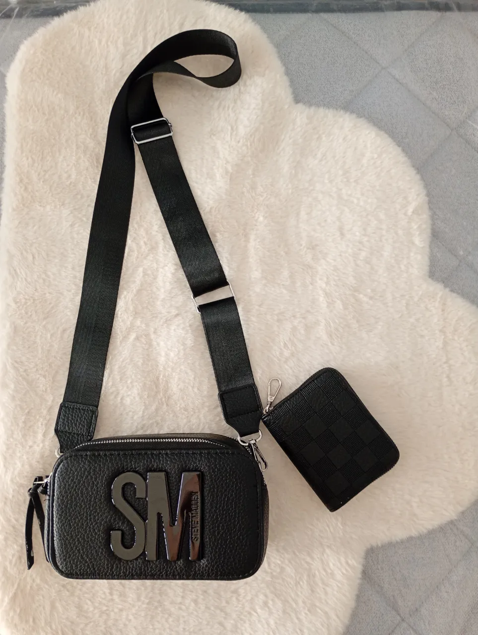 Bolso negro con logo grande 'SM' en el frente. Incluye un monedero a juego con cierre.