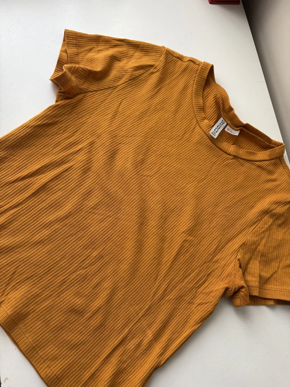 Remera de manga corta, escote redondo y textura acanalada.