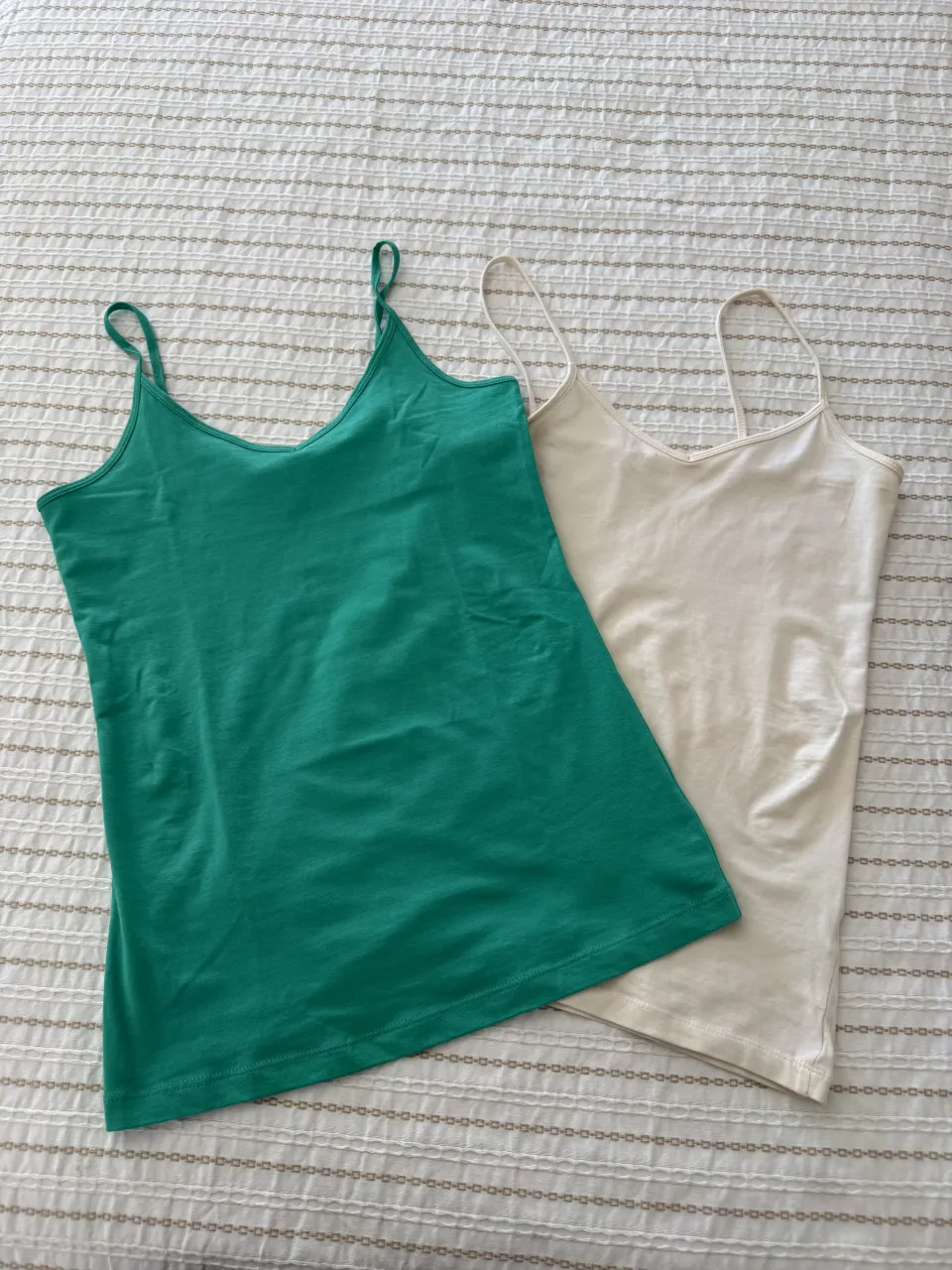 Dos musculosas básicas, una verde esmeralda y otra color crudo. Ambas con tiras finas.