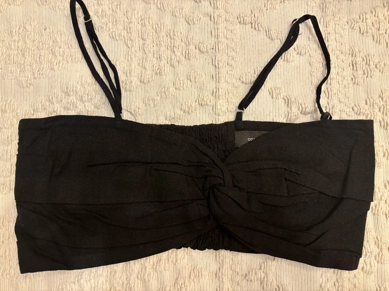 Top negro con detalle de nudo en el frente. Breteles finos ajustables. Ideal para una salida.