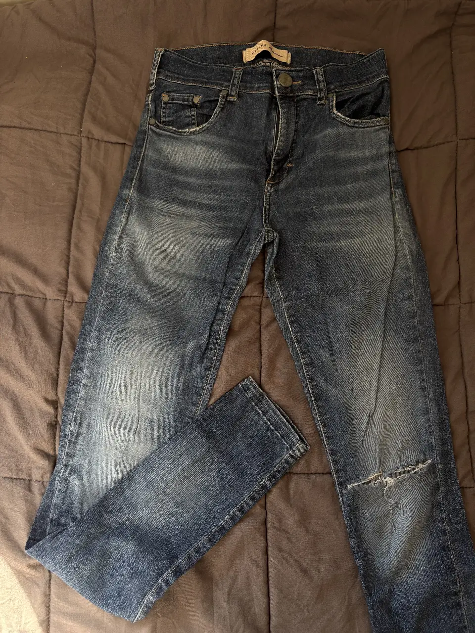 Jeans de mujer azul con roturas en la rodilla. Tiro medio y corte recto, skinny. 
