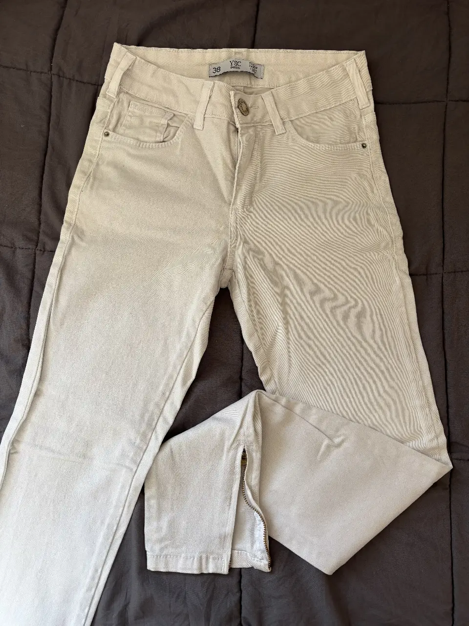 Jeans skinny color blanco con cierre en el tobillo. 