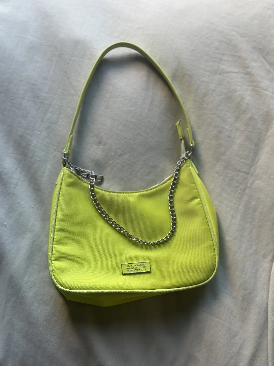 Cartera baguette de color verde lima con cadena plateada. Ideal para un look moderno y canchero.