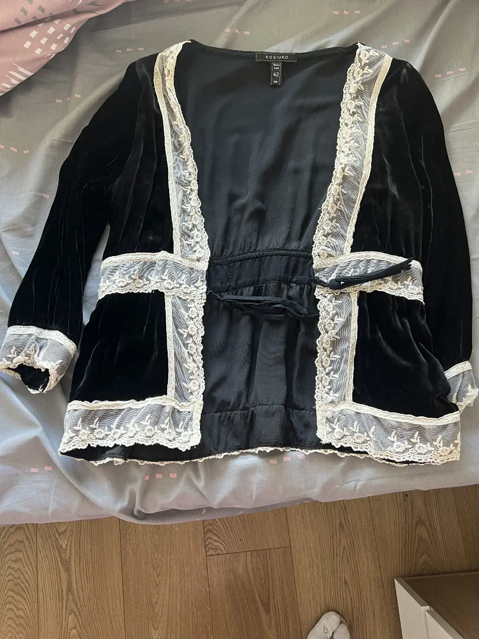 Blusa de terciopelo negro con detalles de encaje blanco. Corte elegante y sofisticado, ideal para ocasiones especiales. Talle 42.