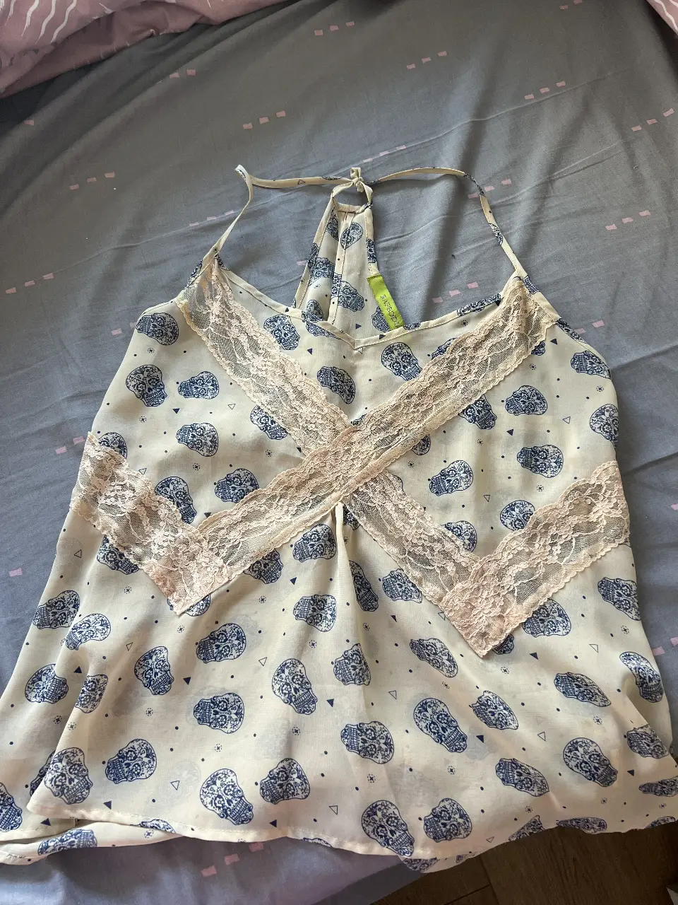 Musculosa de mujer con estampado de calaveras en color azul sobre fondo blanco. Detalles de encaje en el escote. Ideal para un look casual y con onda.