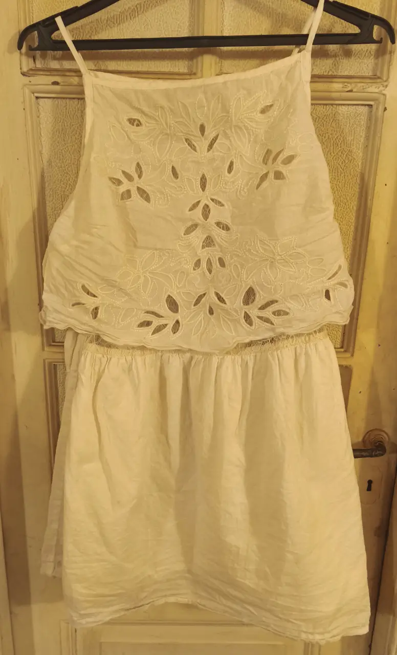 Vestido mini blanco con detalles calados y volados. Ideal para un look fresco y femenino.