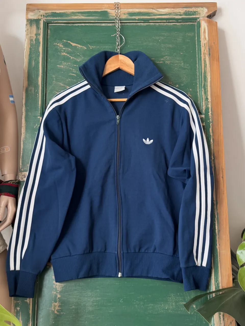 Campera ADIDAS original deportiva azul marino con las icónicas tres tiras blancas en las mangas. Logo de la marca bordado en el pecho. Cuello alto y cierre completo. Ideal para un look casual y deportivo.
