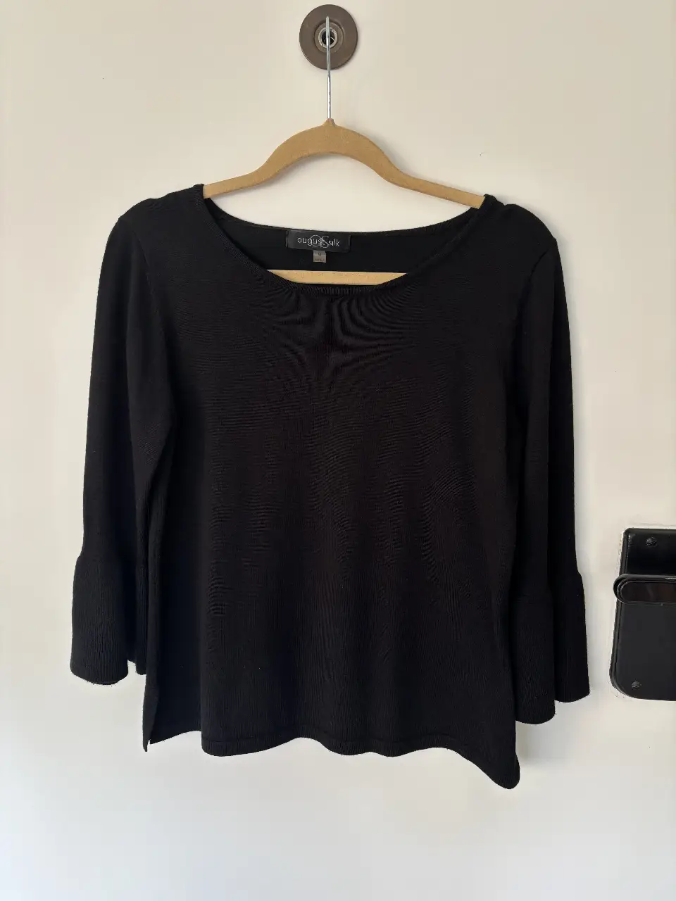 sweater negro de manga 3/4 con campana, ideal para un look elegante y versátil. Confeccionada en tejido suave y cómodo, perfecta para combinar con diferentes outfits.