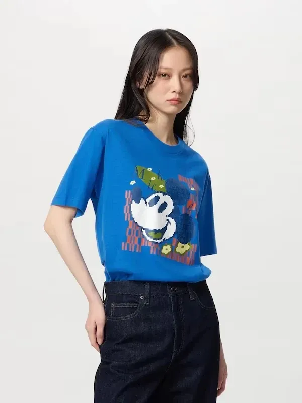 Remera Unisex azul con estampa de Mickey Mouse  pixelada y detalles en naranja y verde.