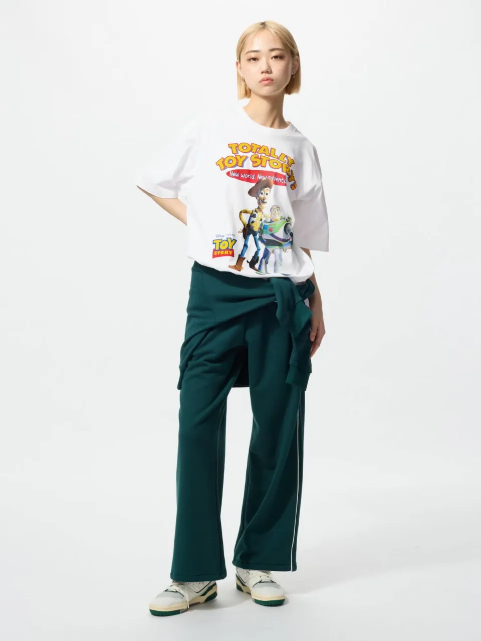 Remera Unisex blanca con estampa de Toy Story, con los personajes de Woody y Buzz Lightyear. La estampa incluye el logo de Toy Story y la frase "Totally Toy Story! New world. New adventure."