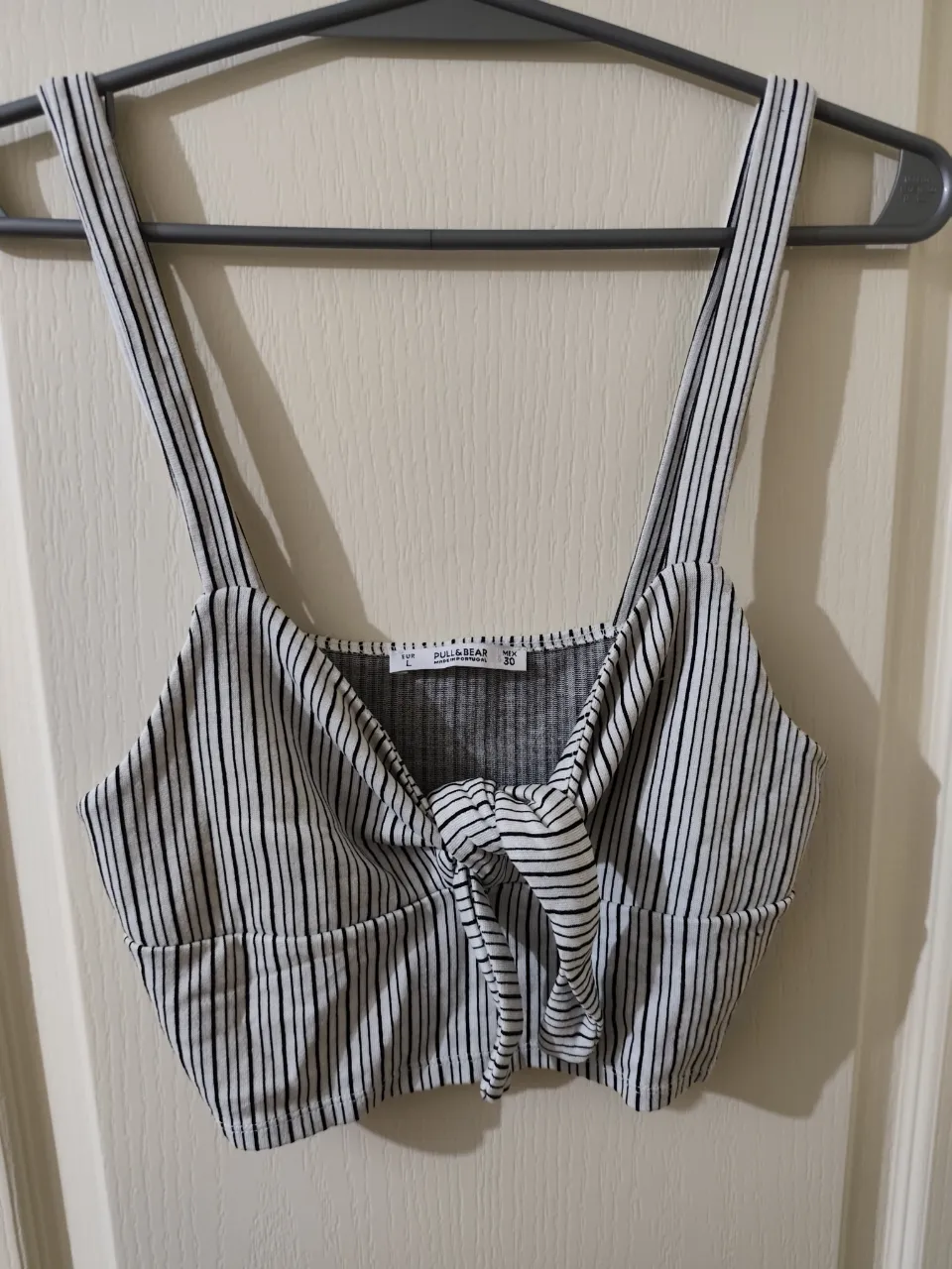 Top a rayas blancas y negras con nudo en el frente y tiras.