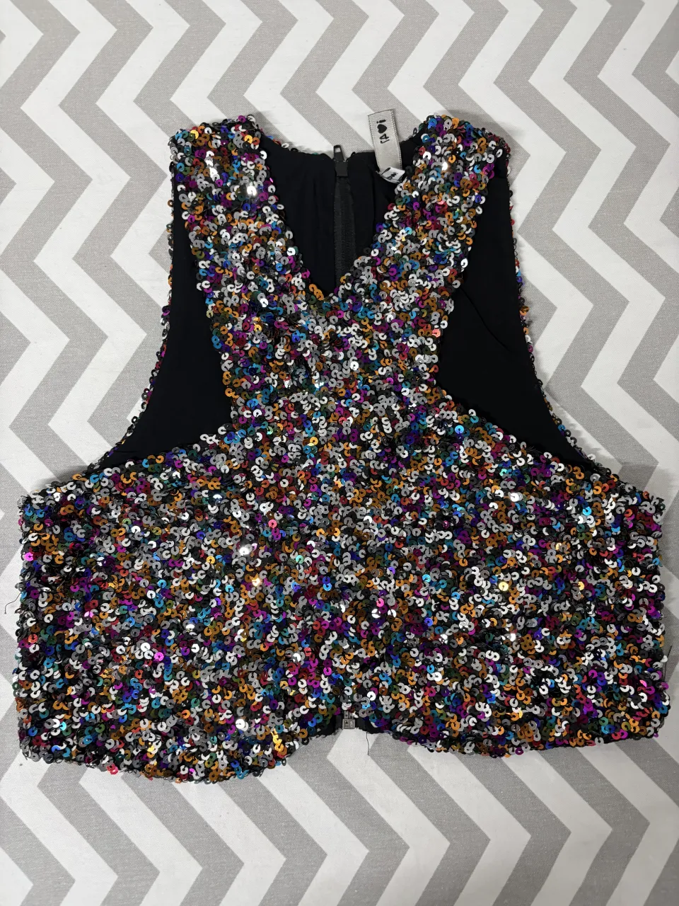 Top de fiesta con lentejuelas multicolor y cierre al frente. ¡Ideal para brillar en cualquier ocasión especial!