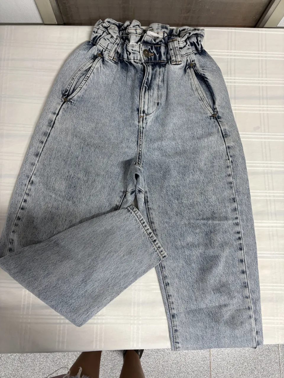 Jeans tiro alto con efecto lavado y fruncido en la cintura. Un modelo súper canchero y cómodo, ideal para armar looks modernos y relajados. Combinan a la perfección con tops, remeras o camisas.