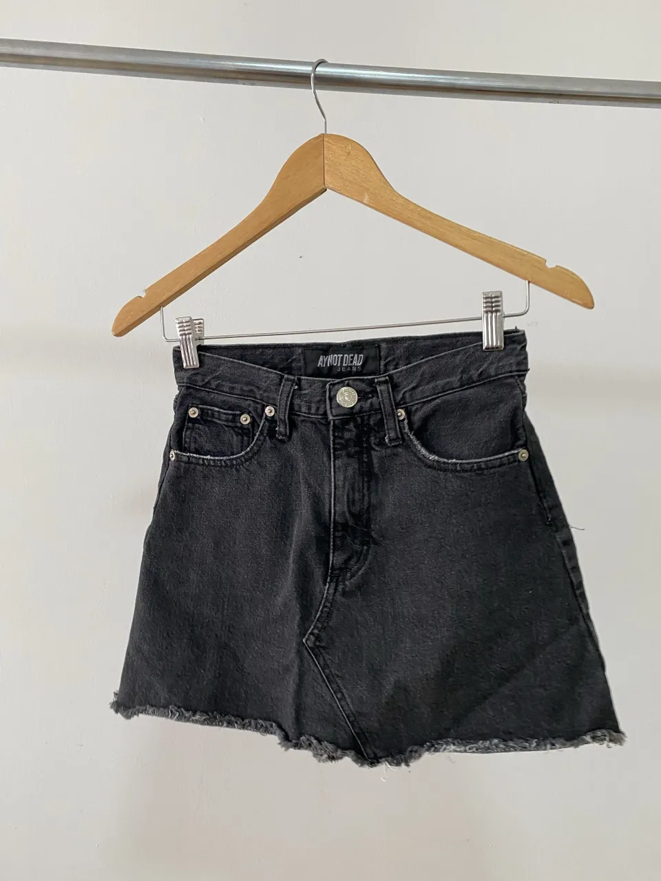 Pollera de jean negra con roturas y terminación deshilachada.