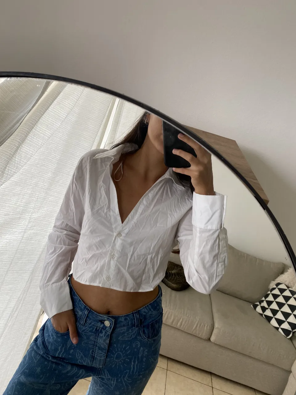 Camisa blanca de algodón, manga larga, con botones al frente y corte crop. Un básico versátil para cualquier look.