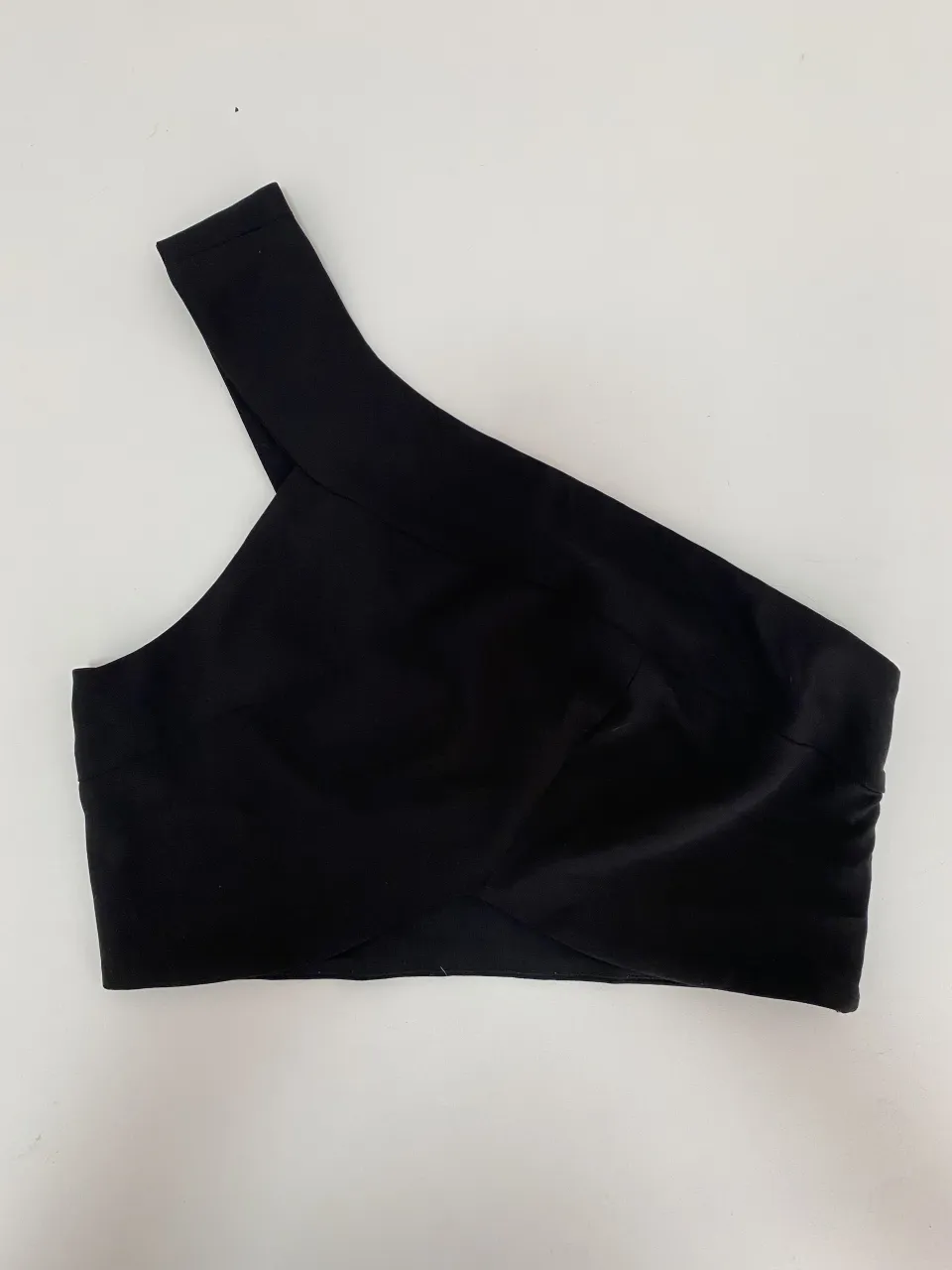 Top negro de un solo hombro, ideal para un look canchero y moderno. Perfecto para salidas nocturnas o eventos especiales.