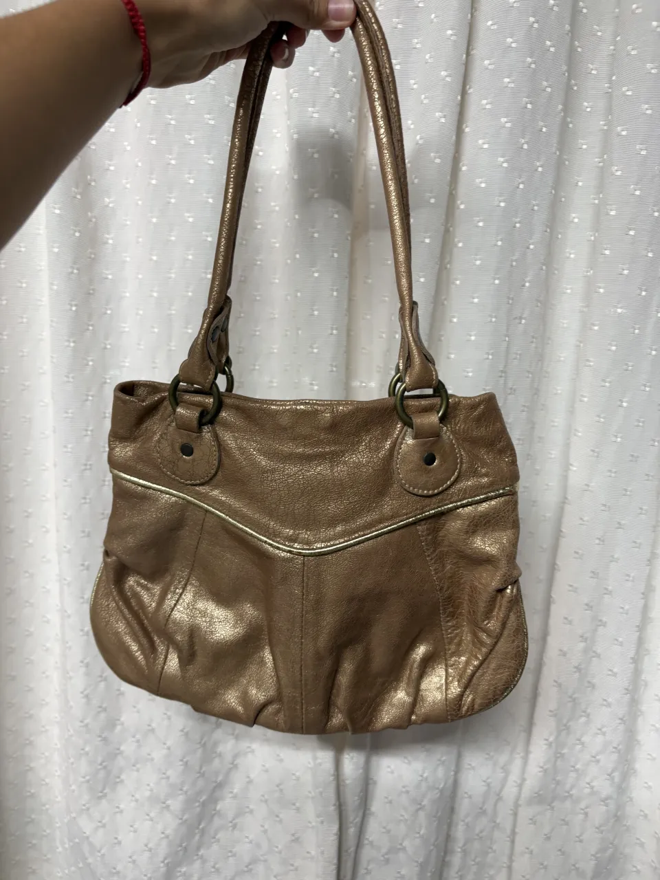 ¡Canjeá tu estilo con esta cartera súper canchera! Su color bronce metalizado le da un toque moderno y sofisticado, perfecta para elevar cualquier look. Ideal para llevar tus esenciales con onda. ¡No te la pierdas!