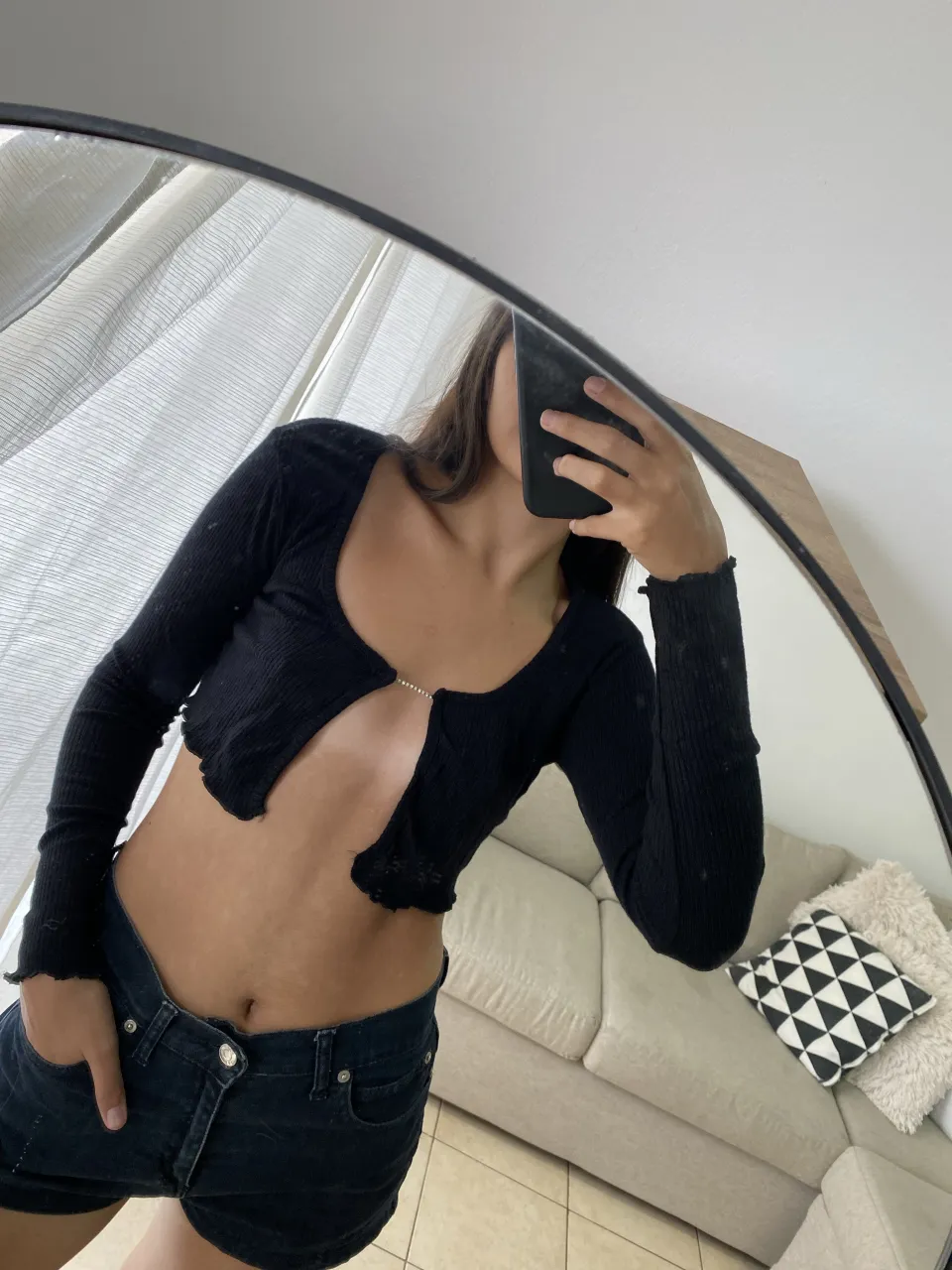 Top negro súper canchero, manga larga y escote pronunciado con detalle de strass en el centro. Tiene un corte al cuerpo y terminaciones con voladitos. Ideal para un look de noche o para darle un toque especial a un outfit casual.