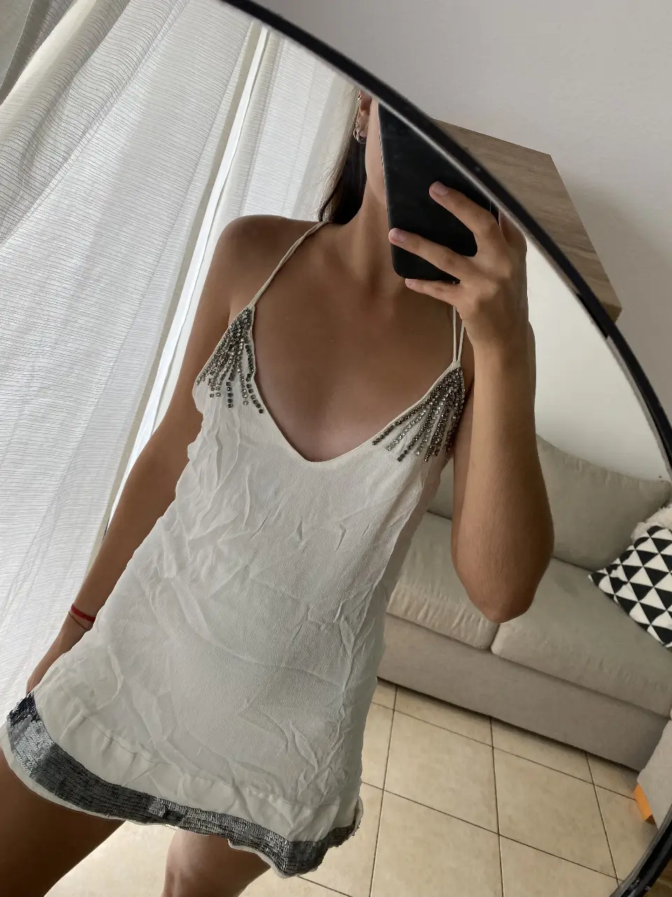 Vestido mini blanco con detalles plateados en el borde inferior y en los tirantes. Ideal para una fiesta o salida nocturna.