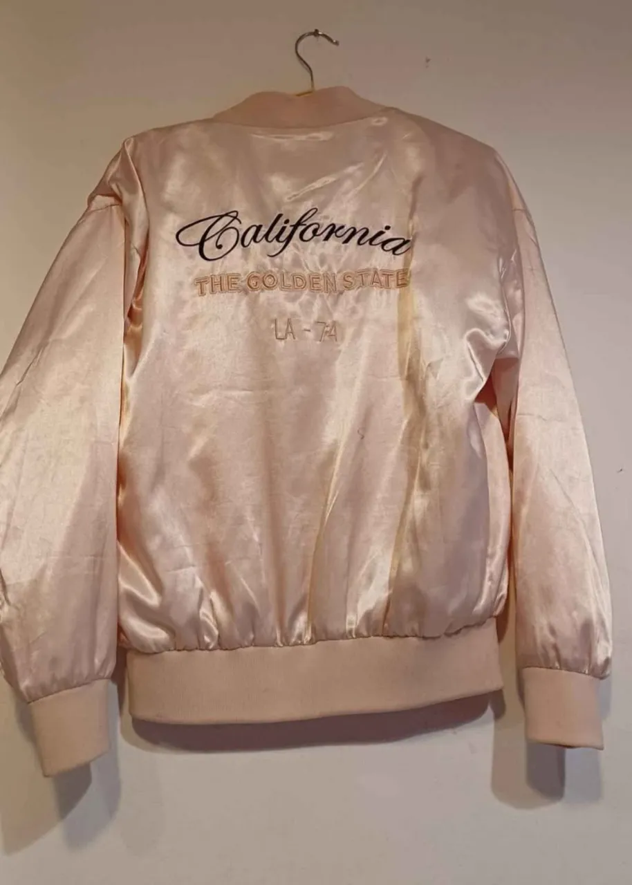 Campera bomber de satén rosa con bordado "California" y detalles "LA-74". Ideal para un look casual y vintage.