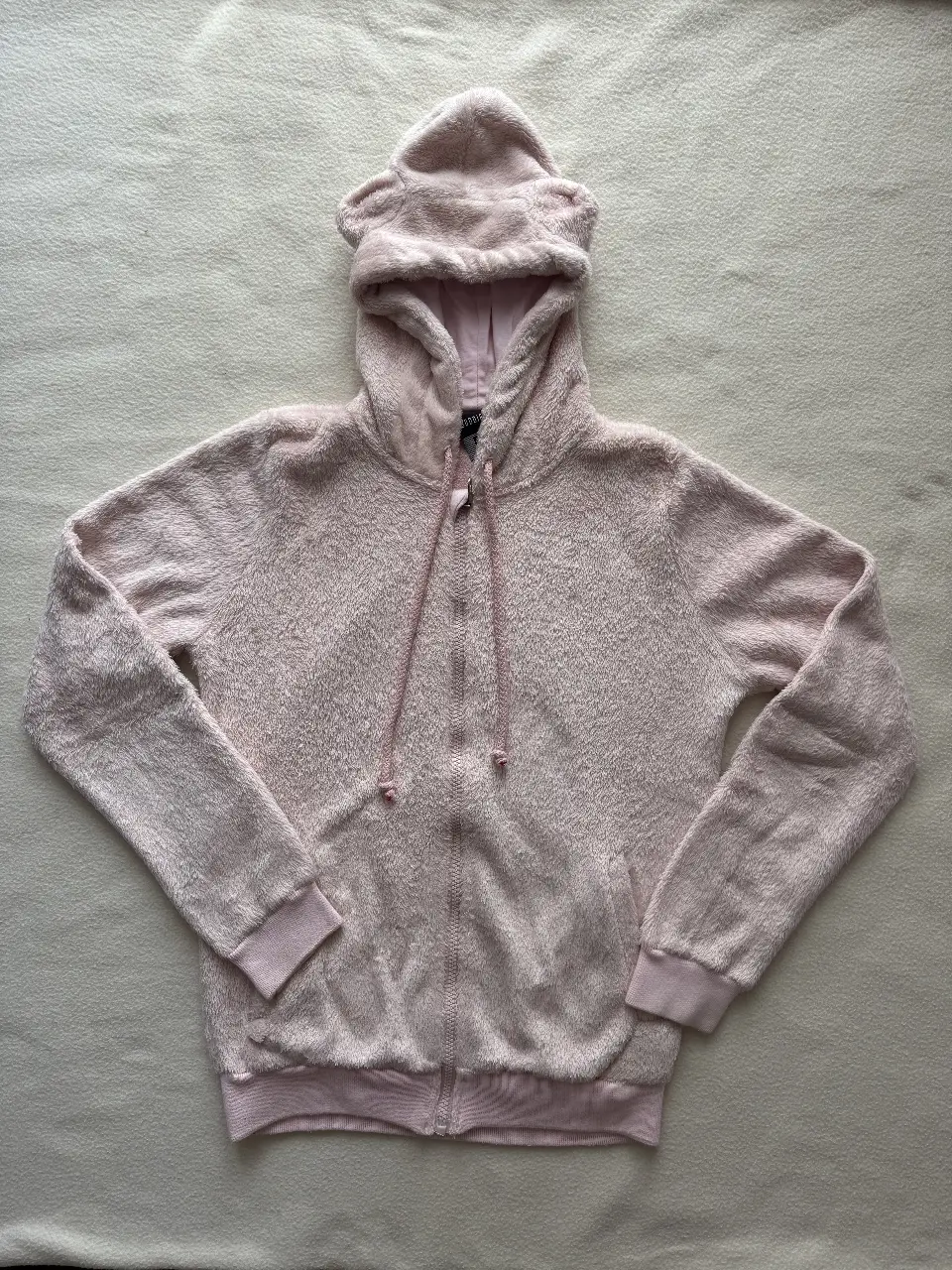 Buzo marca Buddies con cierre y capucha con orejitas, color rosa bebé, ideal para estar cómoda y abrigada. Sin uso, talle 16. Las medidas son: de largo tiene 59 cm, de ancho 44 cm y de largo de mangas 61 cm. En mi perfil pueden encontrar la misma campera en color verde agua.