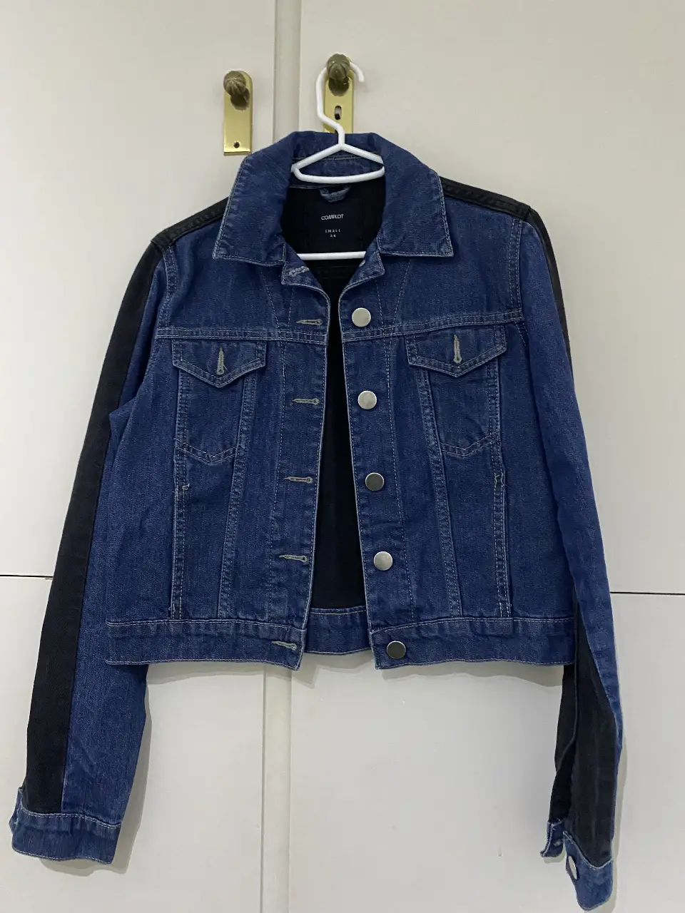 Campera de jean con mangas negras, ideal para un look casual y canchero. Perfecta para usar en cualquier ocasión.