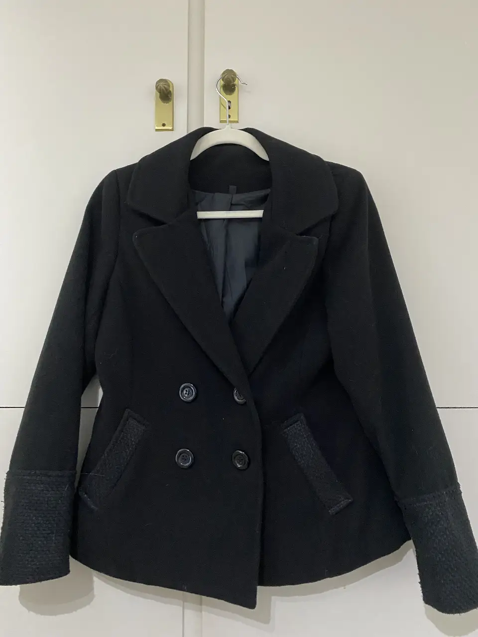 Tapado negro de paño, con botones y bolsillos. Ideal para el invierno.