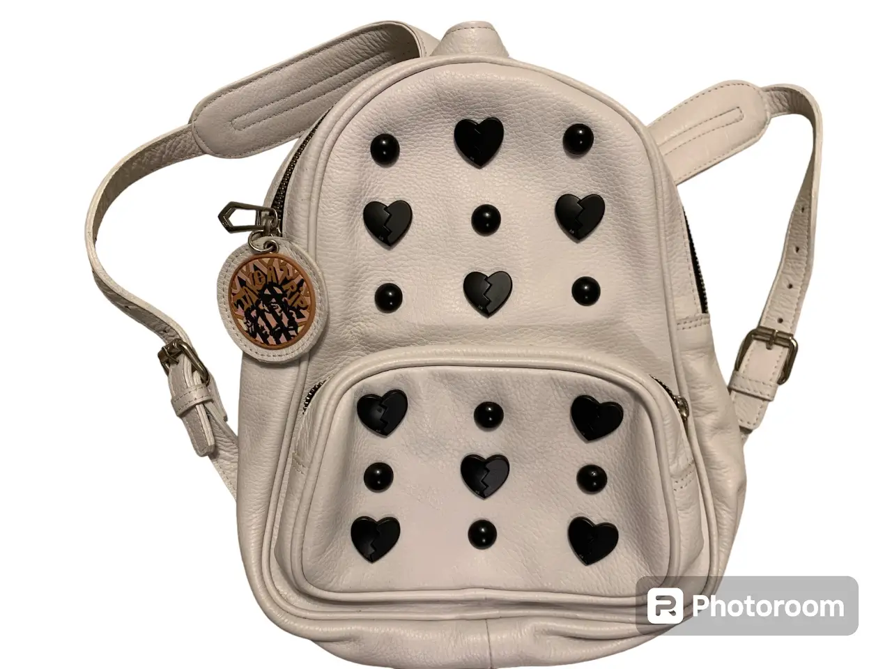 Mochila blanca con detalles de corazones y tachas negras. Ideal para un look moderno y canchero.