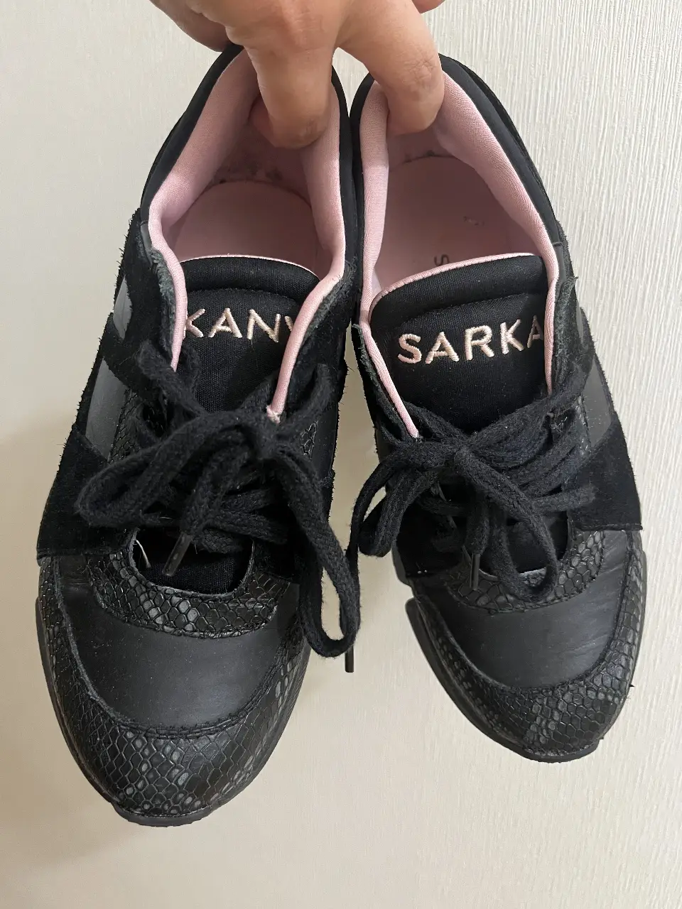 Zapatillas negras con detalles en rosa y suela gruesa. Diseño moderno y urbano, ideales para un look casual y con estilo.