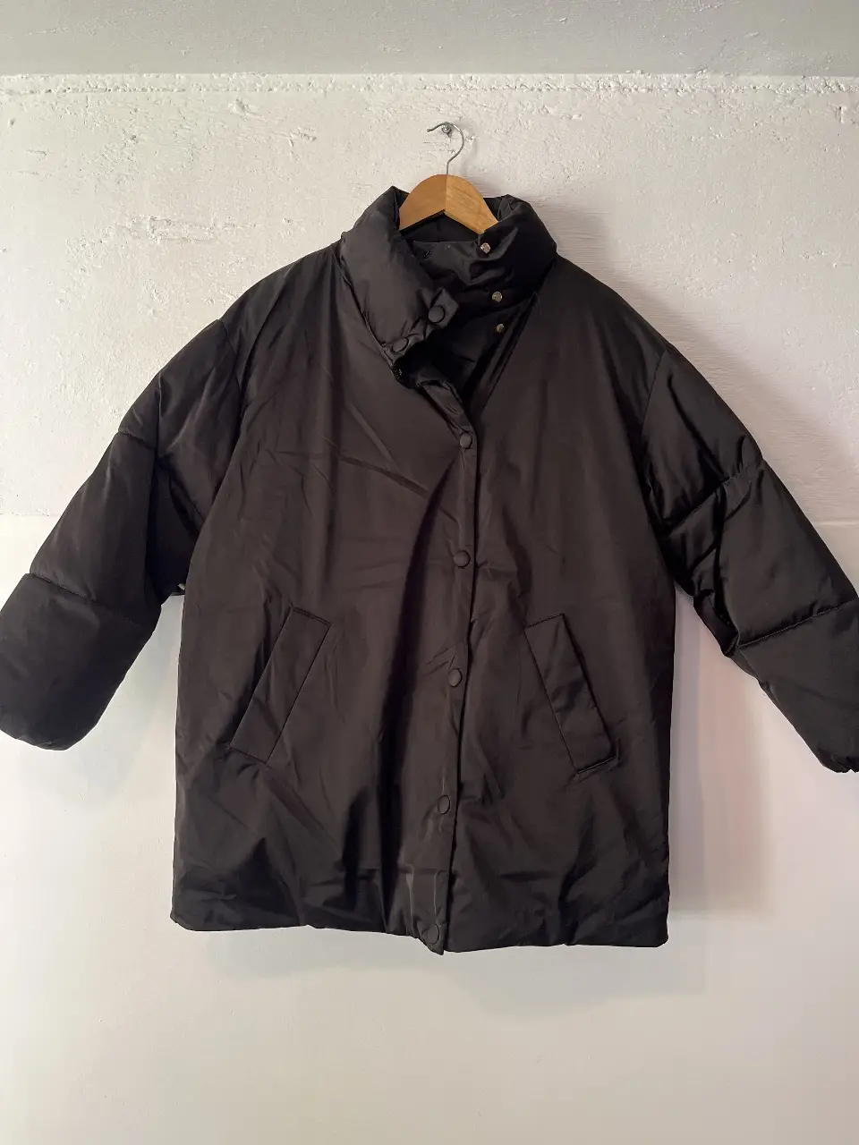 Campera puffer negra, ideal para el invierno. Con cuello alto y cierre con botones. Perfecta para un look casual y abrigado.