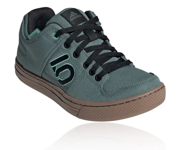 Zapatillas deportivas de lona con cordones negros y suela marrón. Tienen un logo lateral con el número "5" en negro y contorno negro.