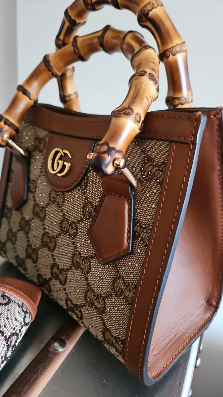 Cartera Gucci con manija de bambú y monograma GG. Diseño elegante y sofisticado, ideal para complementar cualquier look.