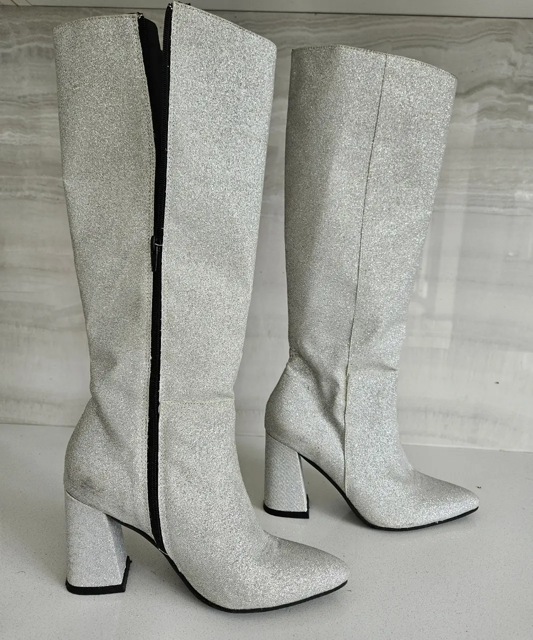 Botas de caña alta plateadas con brillo, ideales para fiestas y eventos especiales. Con cierre lateral y taco ancho para mayor comodidad.
