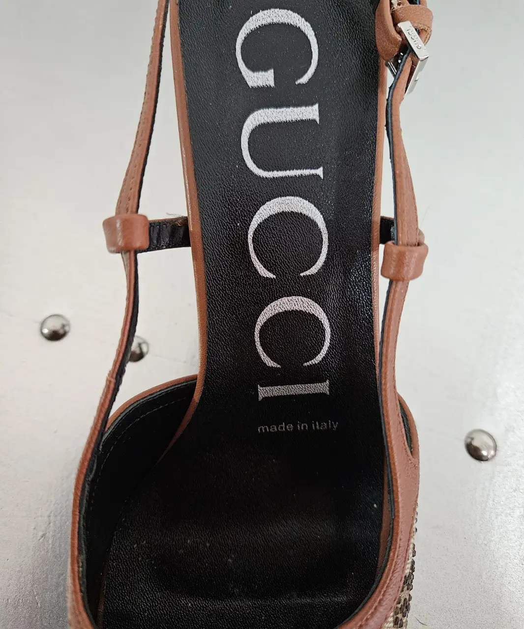 Sandalias Gucci con monograma GG y detalles dorados. Tiras finas y hebilla en el tobillo. Made in Italy.