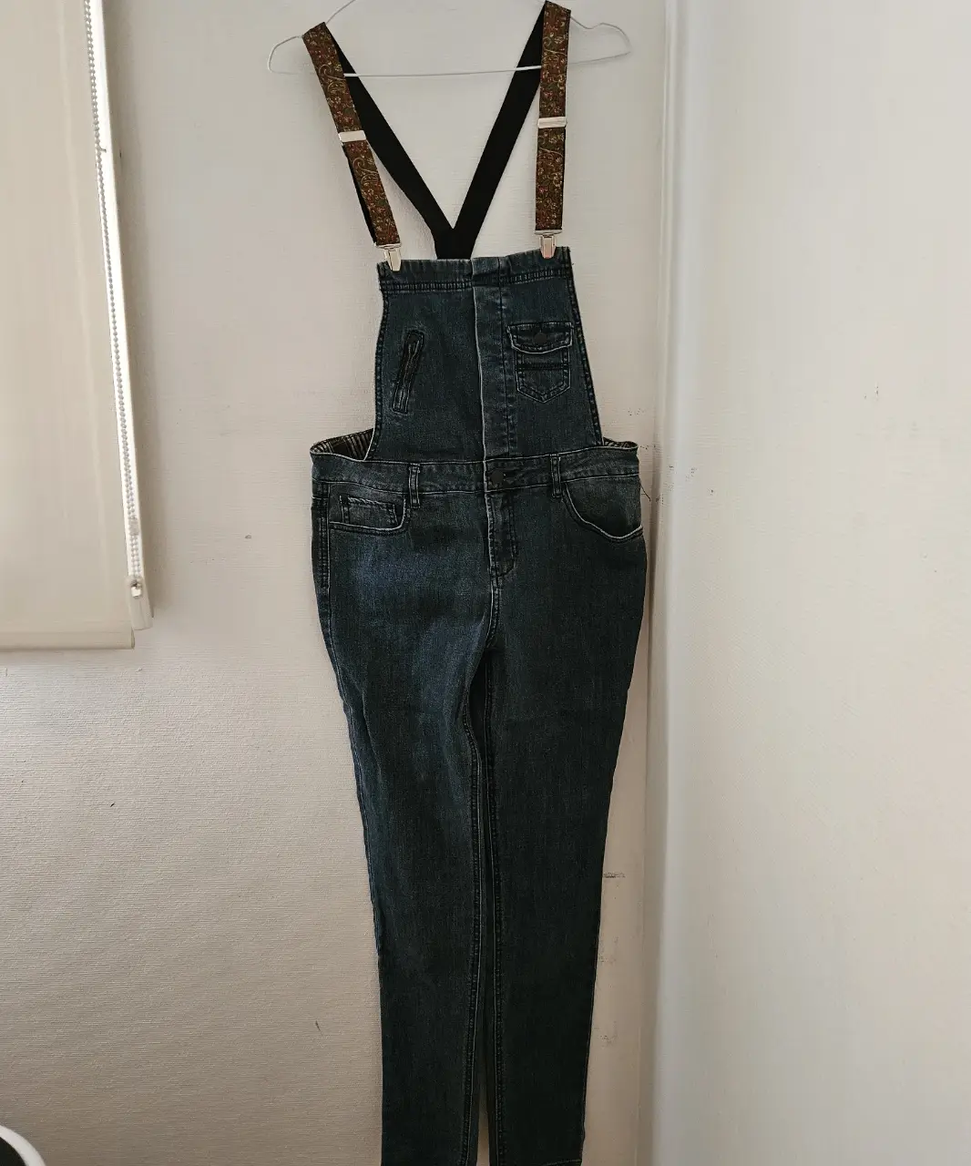 Overol de jean azul oscuro con tiradores estampados y forro a cuadros. Un clásico reinventado con un toque de estilo único.