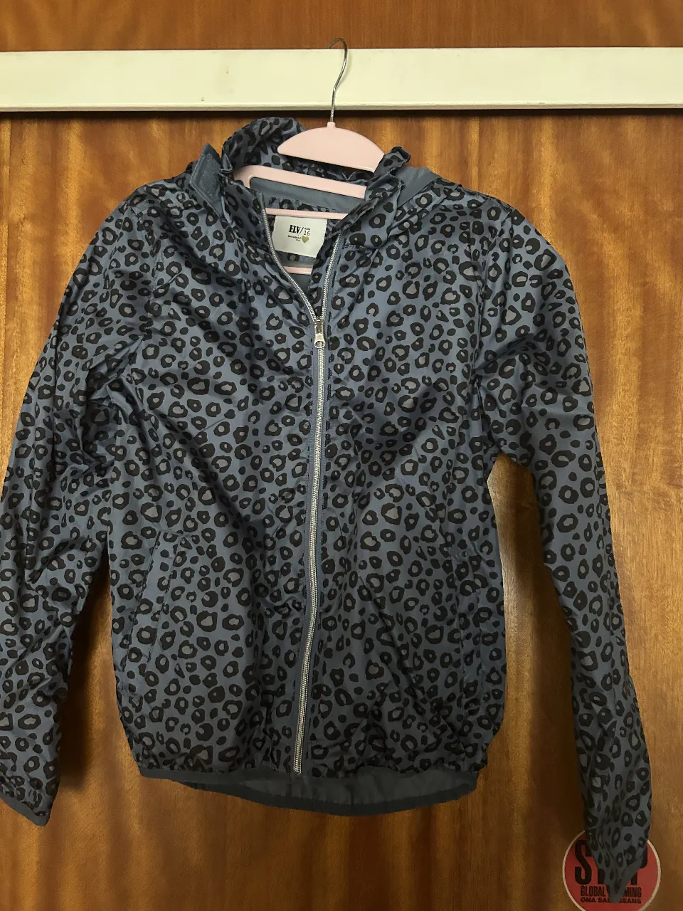 Campera impermeable con estampa de leopardo en tonos azules y grises. Posee capucha y cierre al frente. Ideal para un look canchero y moderno.